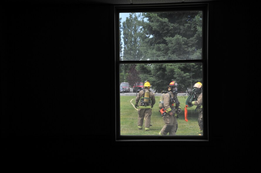 Airmen from the 92nd Civil Engineer Squadron and Air Force Space Command prepare their equipment prior to participating in Rapid Intervention Team training at Fairchild Air Force Base, Washington, June 13, 2014. Fairchild hosted 14 Airmen from seven separate fire stations throughout the Air Force Space Command. Teams of two train together in buildings compiled with scenarios that help mimic the real life possibilities of being trapped, injured or lost. (U.S. Air Force photo/Staff Sgt. Alexandre Montes)