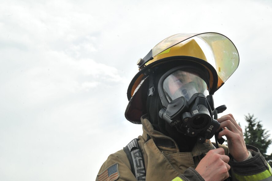 An Airmen from the 92nd Civil Engineer Squadron prepares his equipment prior to participating in Rapid Intervention Team training at Fairchild Air Force Base, Wash., June 13, 2014. Fairchild hosted 14 Airmen from seven separate Fire Stations throughout the Air Force Space Command. Teams of two train together in buildings compiled with scenarios that help mimic the real life possibilities of being trapped, injured or lost. (U.S. Air Force photo by Staff Sgt. Alexandre Montes/Released)