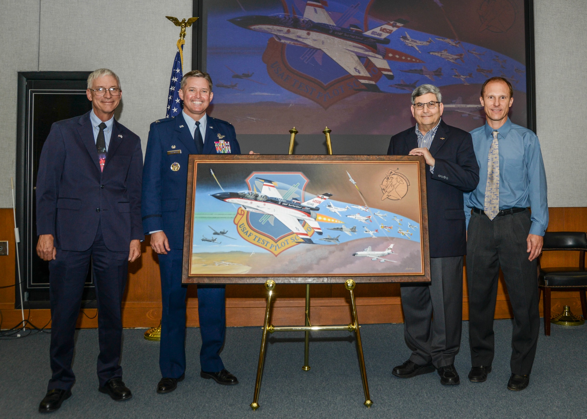 Aviation artist and author Mike Machat unveiled his 70th anniversary painting, “TPS Generations” June 13. Machat is shown here with three of the painting’s five commissioners, (from left to right) Randolph Kelly, TPS master instructor, Systems Division; Col. Lars Hoffman, TPS commandant, Machat and David Vanhoy, TPS technical director. 