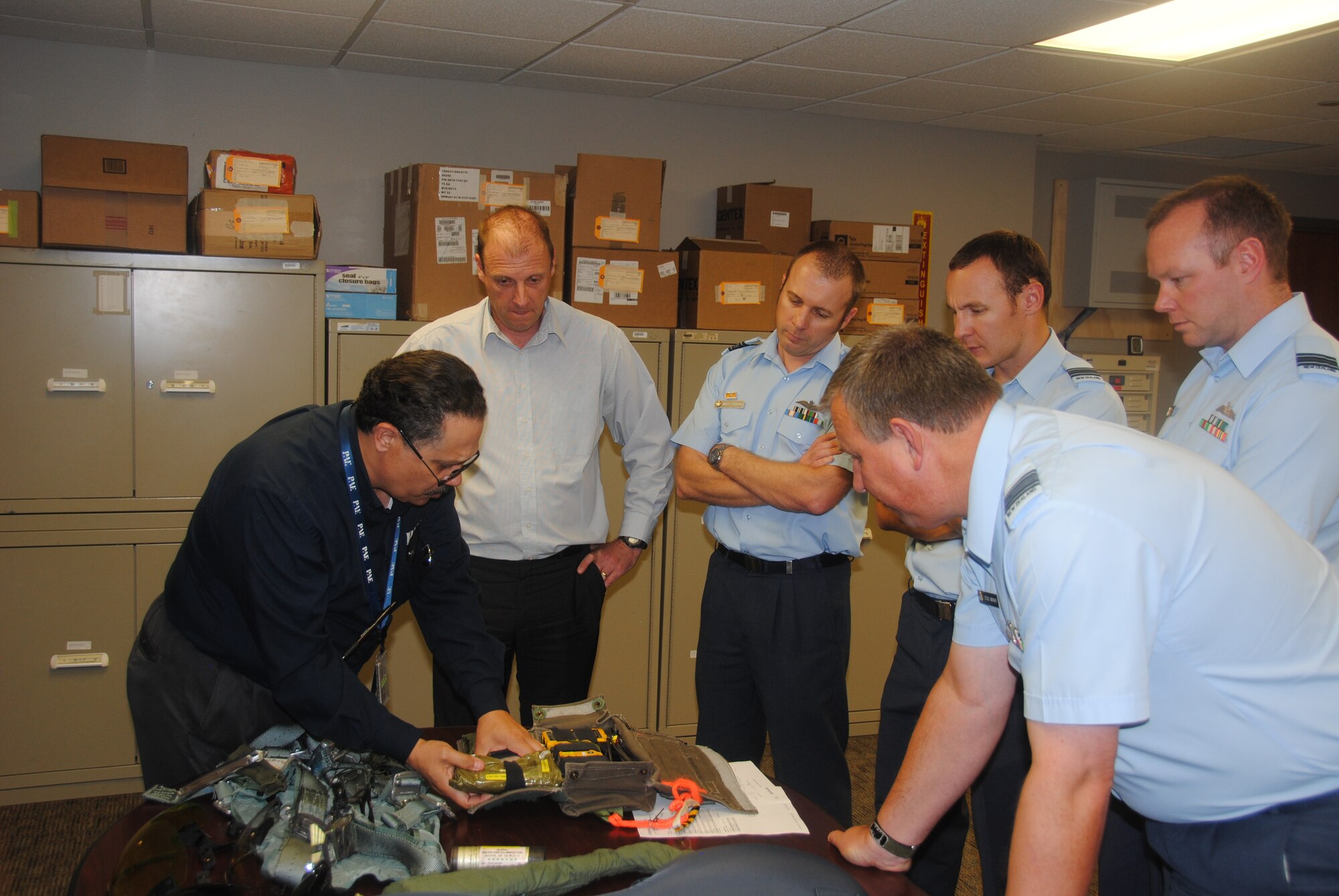VANCE AIR FORCE BASE, Okla. -- Wildo Rosario, the Life Support Flight production supervisor, explains the contents of an emergency kit on the ejection seat of a T-6 Texan II to New Zealand Air Force representatives June 16 at the Life Support shop here. The New Zealanders visited Vance to gain a greater understanding of the T-6 Texan II which they purchased earlier this year. (U.S. Air Force photo/2nd Lt. Mark Habermeyer)
