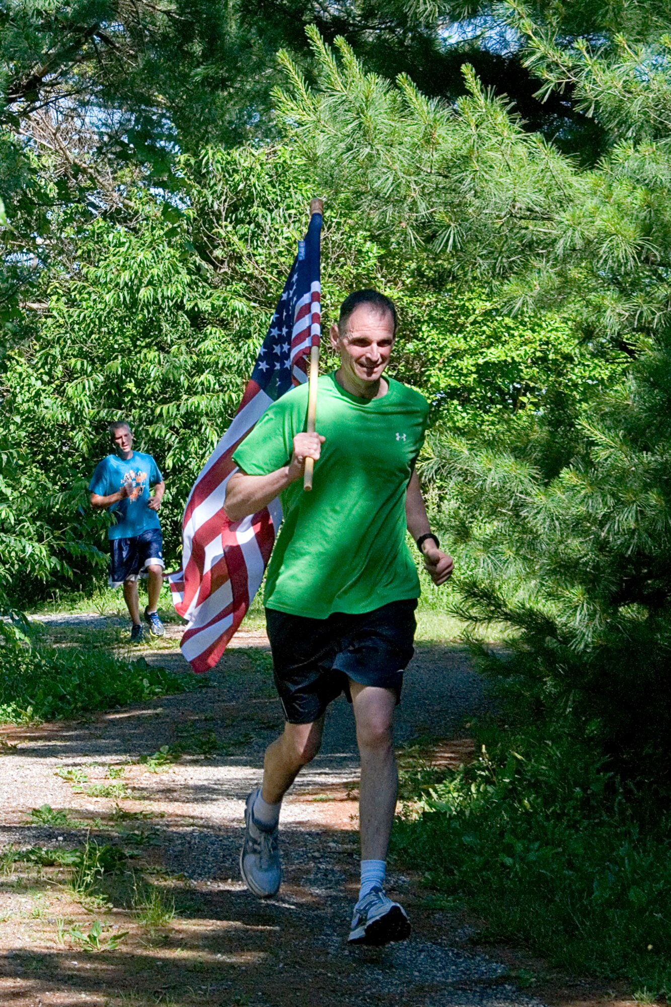 Marty Foye, 434th Air Refueling Wing financial services officer, runs through a shaded area of the running trail June 13, 2014 at Grissom Air Reserve Base, Ind., during a flag run. The run, sponsored by the 434th Force Support Squadron, was designed to promote esprit de corps and promote physical fitness. (U.S. Air Force photo/Tech. Sgt. Douglas Hays)