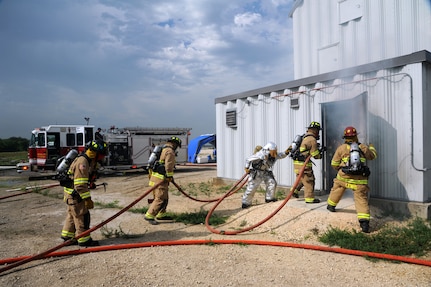 Members of the Universal City Fire Department train with 502nd Civil Engineer Squadron firefighters June 12 during structural live-fire training at Joint Base San Antonio-Randolph. (U.S. Air Force photo by Melissa Peterson)