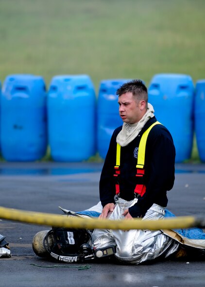 A firefighter from the 179th Airlift Wing, Mansfield Lahm Air National Guard Base, Ohio, rests after training in a structural fire simulation building here, June 18, 2014. More than 20 Mansfield firefighters came to Youngstown June 17-18 to complete annual training at the fire training area. The training included internal and external firefighting using an ignitable mock aircraft and firefighting inside the structural fire simulation building. U.S. Air Force photo/Eric M. White