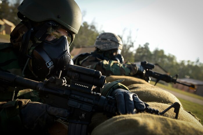 Senior Airman Leigh Sullivan, 560th Rapid Expeditionary Deployable Heavy Operational Repair Squadron Engineers structures journeyman, provides security in a simulated chemical environment during a field training exercise April 12, 2014, at North Auxiliary Field, S.C. The squadron's mission during the exercise is to install bare base assets and conduct heavy repair to enable follow-on C-17 Globemaster operations within 72 hours at a simulated Forward Operating Base. (U.S. Air Force photo/Staff Sgt. Corey Hook)
