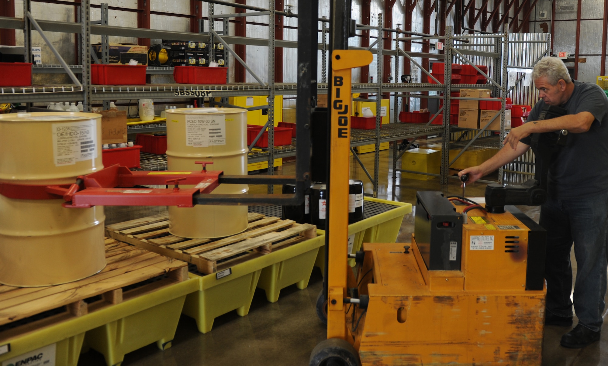 Gary Bush, 375th Logistics Readiness Squadron material handler, operates a forklift to move oil that is used in the C-21 Learjet in the Hazardous Material Pharmacy June 11, 2014 at Scott Air Force Base. Bush is one of two handlers who run the HAZMART by keeping track of what hazardous material is kept or needed on base. ( U.S. Air Force photo/ Senior Airman Joshua Eikren)