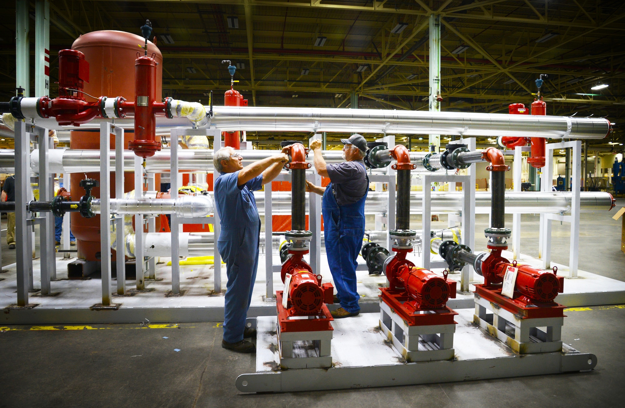 Pipefitters Kenneth Shepherd and Michael Mills with the 776th Maintenance Support Squadron, tighten flanges on piping for  the B-1 Centralized Aircraft Support System, which will soon replace outdated systems that are currently in use. (Air Force photo by Kelly White)