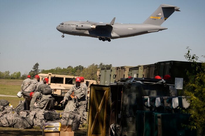 Airmen from the 560th Rapid Expeditionary Deployable Heavy Operational Repair Squadron Engineers Squadron unload gear during a field training exercise Apr. 10, 2014, at North Auxiliary Field, S.C. The squadron's mission during the exercise is to install bare base assets and conduct heavy repair to enable follow-on C-17 operations within 72 hours at a simulated Forward Operating Base. (US Air Force photo/ Staff Sgt. Corey Hook)