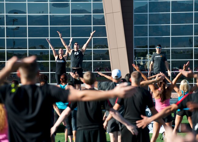 Tony Horton, creator of the P90X workout series, leads warm-up stretches during a Warrior Trained Fitness session at the Warrior Fitness Center, June 17, 2014, at Nellis Air Force Base, Nev. Horton addressed the importance of warming up before a workout and maintaining flexibility. (U.S. Air Force photo by Airman 1st Class Thomas Spangler)