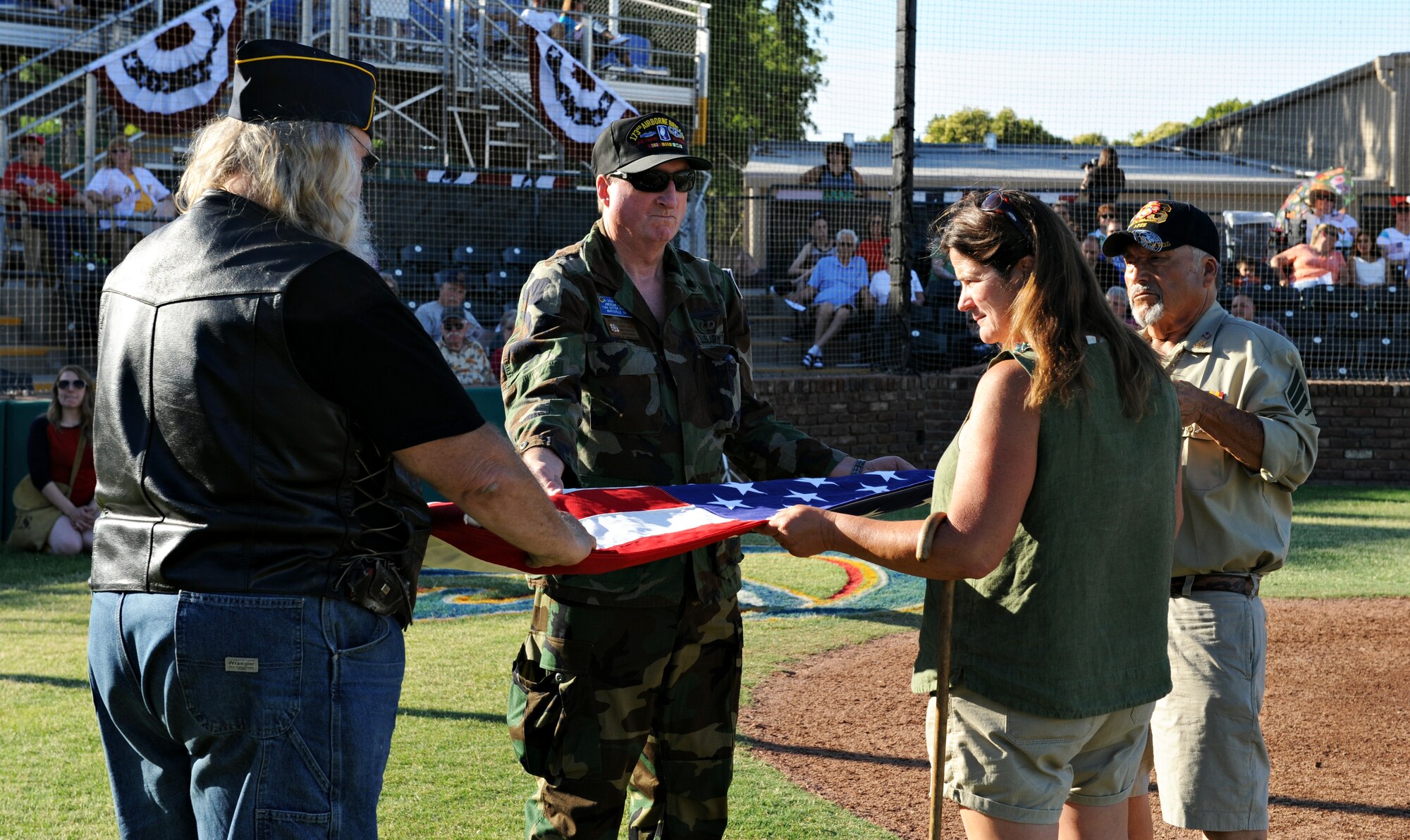 Members from the American Legion Post in Marysville, Calif., demonstrate how to fold the U.S. flag June 14, 2014, during the opening ceremony for the Marysville Gold Sox at the Appeal Democrat Park. (U.S. Air Force photo by Airman 1st Class Ramon A. Adelan/ released)