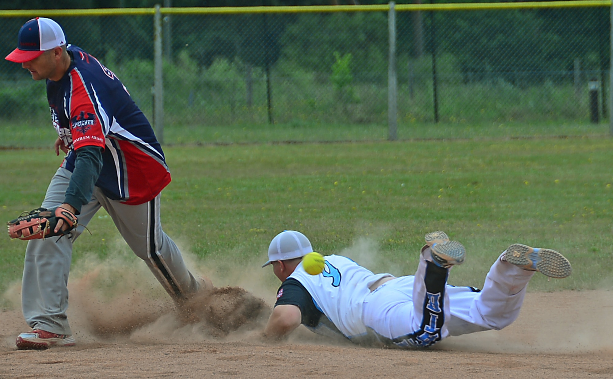 Brian Lee, right, dives for second base during the 3rd Annual U.S. Air Forces in Europe Softball Tournament held at Royal Air Force Lakenheath, England, June 15, 2014. Lee is a supply craftsman assigned to the 352nd Special Operations Maintenance Squadron. (U.S. Air Force photo by Airman 1st Class Erin O’Shea/Released)