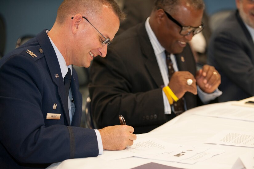 Col. William Knight, 11th Wing/Joint Base Andrews commander, along with Prince George’s County Executive Rushern L. Baker III sign the founding documentation for a “Way Ahead” initiative here, June 5, 2014. The Air Force initiative was created to leverage military installation and local community capabilities and resources with a goal of reducing operating costs in support of the Air Force mission. (U.S. Air Force Photo/Staff Sgt. Robert Cloys)