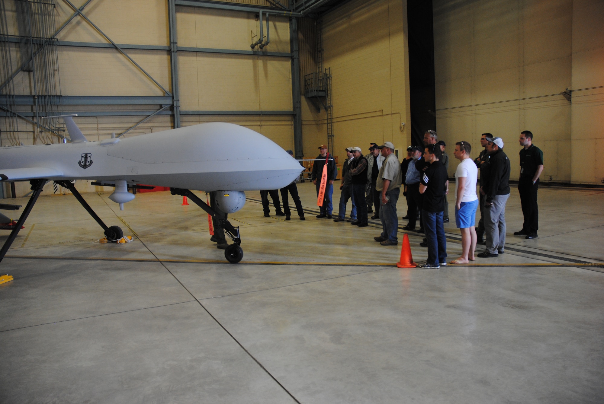 Civilian guests from local flying clubs and organizations recieve a tour of a hangar housing one of the MQ-1 Predators at Grand Forks Air Force Base, N.D. The viewing of MQ-1 Predators was part of tour given to people attending the 2014 M.A.C.A Civil Fly-In held June 14, 2014. (U.S. Air Force photo/Staff Sgt. Luis Loza Gutierrez)