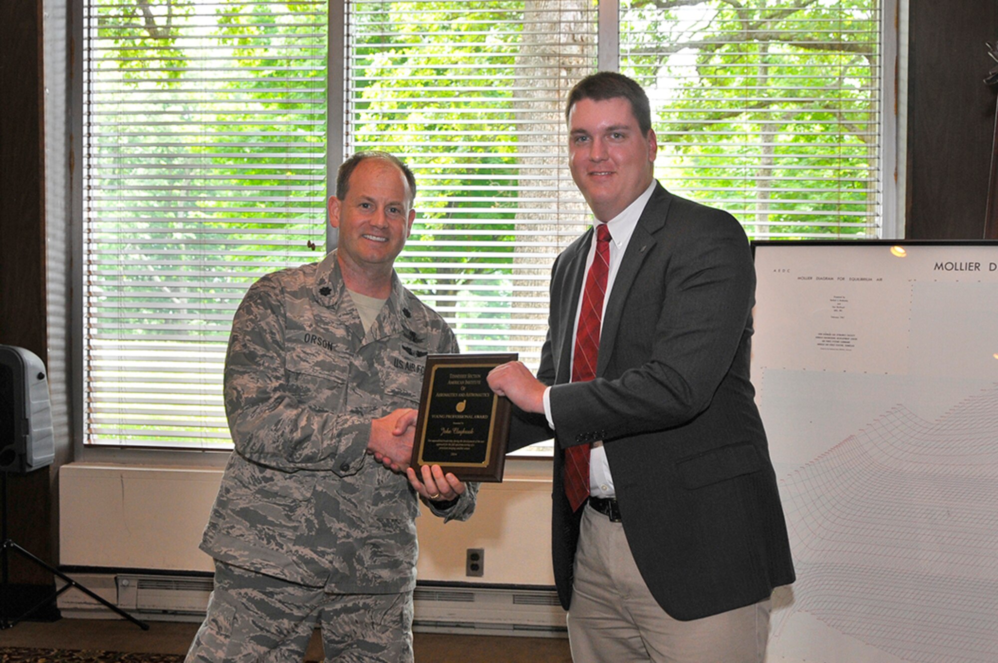 Lt. Col. Jay Orson (left), the AEDC Space and Missile Test Branch director, presents the AIAA Young Professional Award to John Claybrook, with the AEDC Space and Missile Test Branch, for his leadership of the test approach for the full-spectrum testing of a persistent imaging satellite sensor.