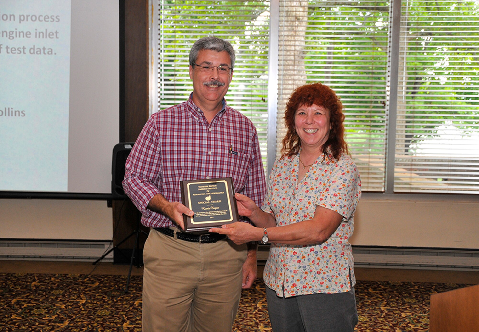 Ronnie Rogers (left), with the ATA Information Technology and Systems Department, receives an AIAA Special Award for the development of an efficient data reduction process for high-response pressure data allowing near, real time data analysis. Judy Bergmann, a senior aerospace engineer with the Miratek Corp., presents the award.