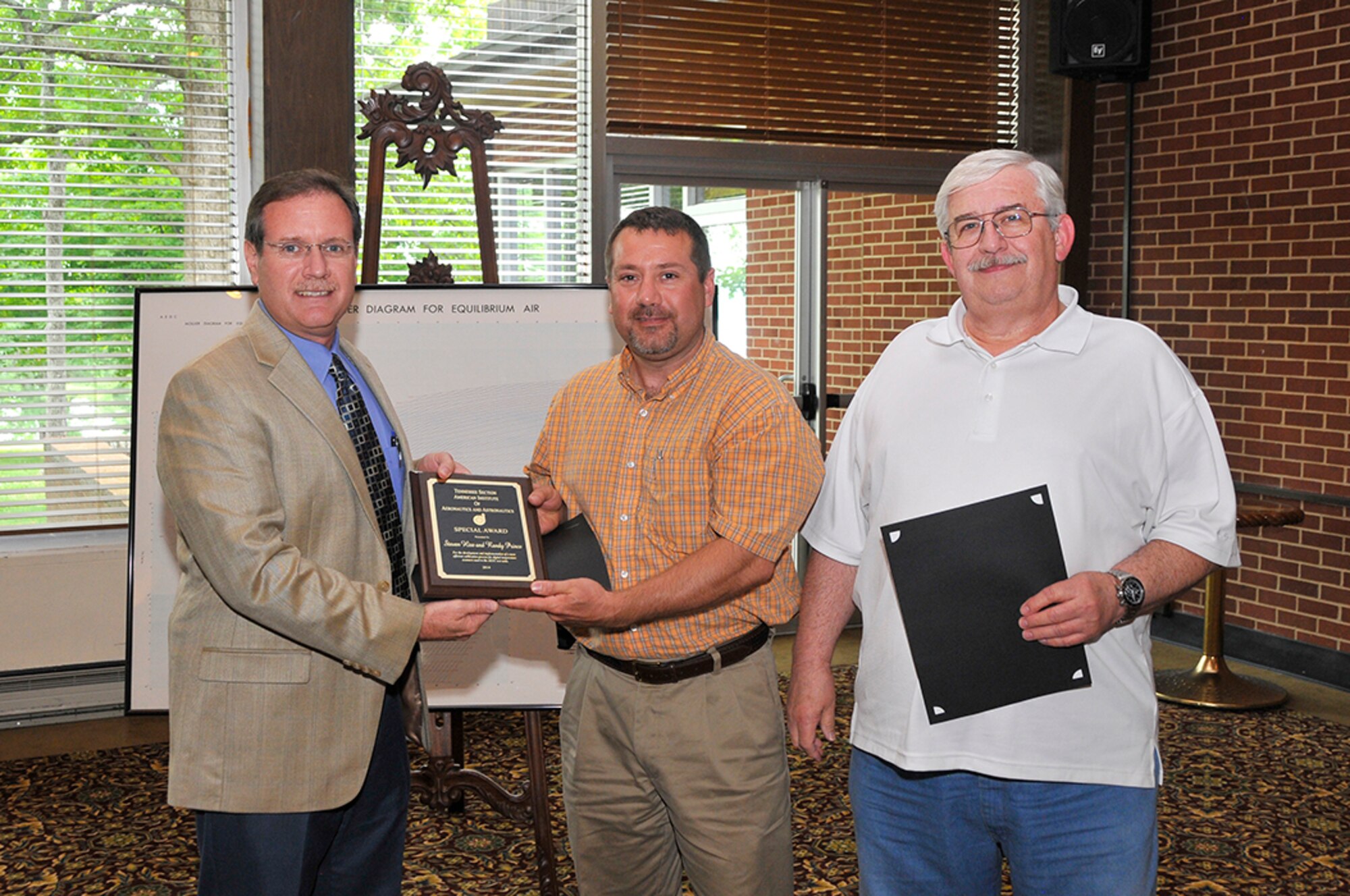 Randy Prince (center) and Steven Hise (right), with the ATA Test Assets and Support Department, receive the AIAA Special Award for the development and implementation of a more efficient calibration process for digital temperature scanners. Mark Rigney, with ATA’s Information Technology and Systems Department, presents the award.