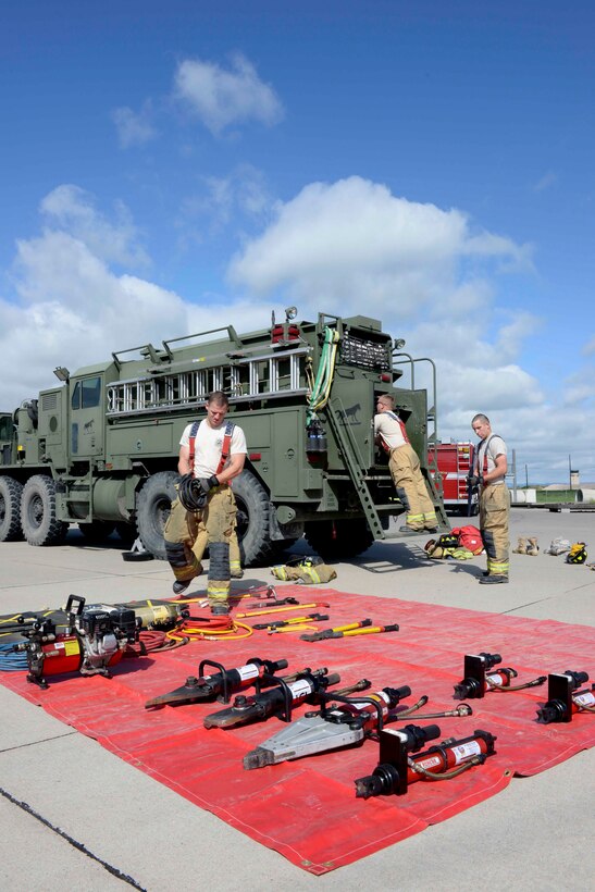 Firefighters from the South Dakota Army National Guard 451st Engineer Detachment set up and prepare for vehicle extrication training during a Golden Coyote Exercise at Ellsworth Air Force Base, S.D., June 12, 2014. The 28th Civil Engineer Squadron firefighters assisted in the exercise by setting up several simulated crash vehicle situations for the SDANG 451st ED firefighters. (U.S. Air Force photo by Senior Airman Anania Tekurio/Released)