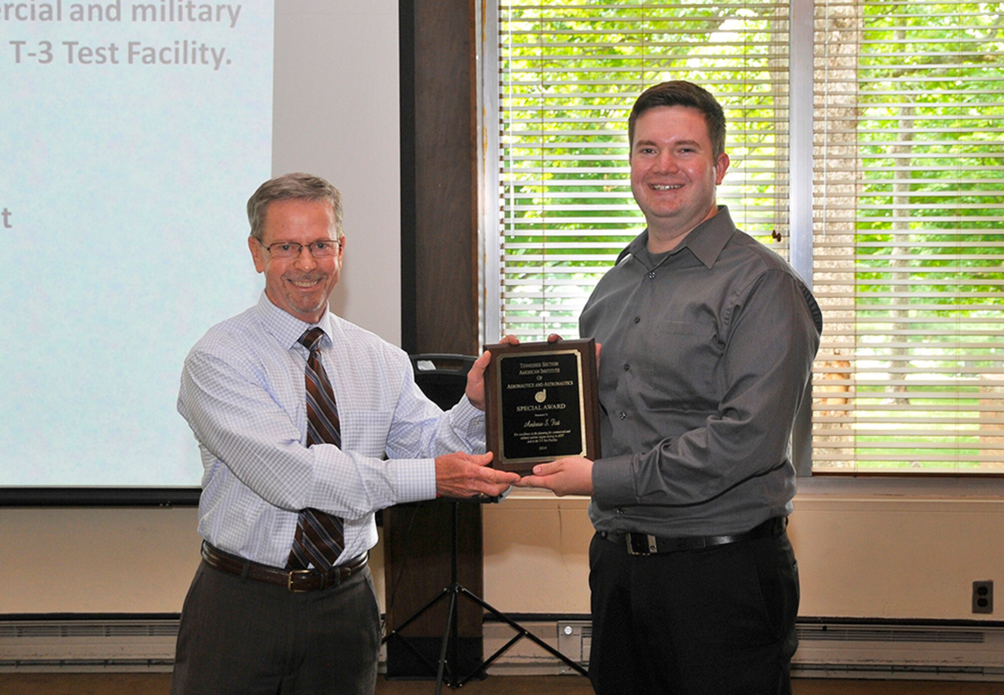 AEDC Engineer Andrew Fist (right) receives the AIAA Special Award for excellence in the planning for commercial and military turbine engine testing in the Aeropropulsion Systems Test Facility and the T-3 engine test cell. Michael Dent, the award nominator with the AEDC Aeropropulsion Ground Test Branch, presents the award.