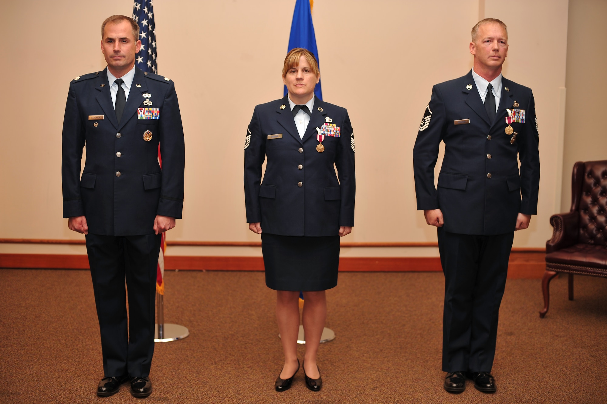 U.S. Air Force Lt. Col. Barton Kenerson, 354th Maintenance Group deputy commander, Master Sgt. Shelly Dunham, 354th MXG training section chief, and Master Sgt. Bradley Dunham, 354th Security Forces Squadron standardization and evaluations superintendent, stand at attention during a retirement ceremony at the Aurora Event Center June 12, 2014, Eielson Air Force Base Alaska. Mr. and Mrs. Dunham retired together in one combined retirement ceremony. (U.S. Air Force photo by Staff Sgt. Jim Araos/Released)