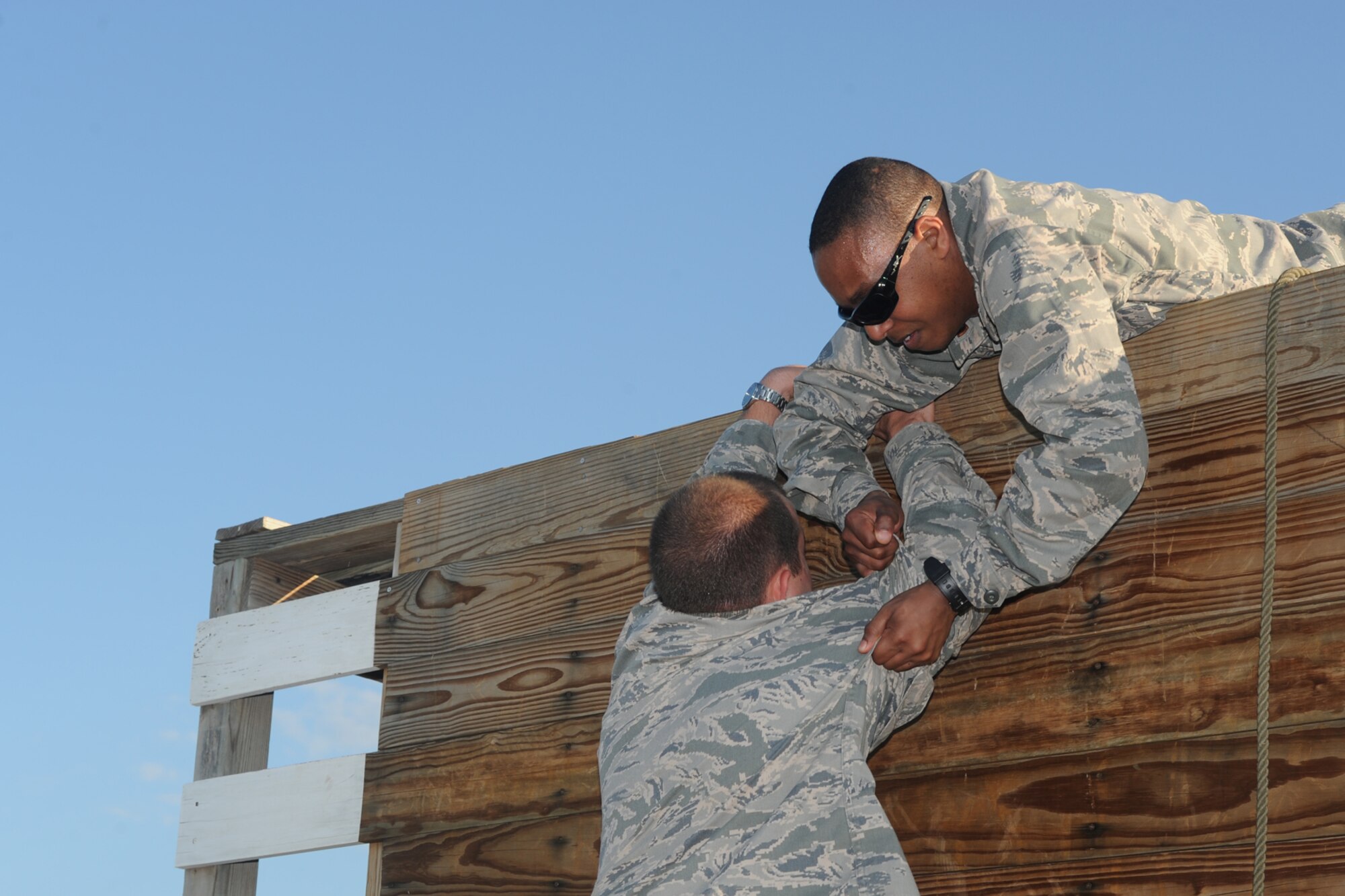 GOODFELLOW AIR FORCE BASE, Texas – Second Lt. Colby E. Felton, Air Force Reserve Command chaplain candidate, helps an Airman climb a wall at the Leadership Readiness Course here May 30. The obstacle course is a team building exercise, which encourages Felton and his team to work together. (U.S. Air Force photo/ 1st Lt. Nathaniel Roesler)