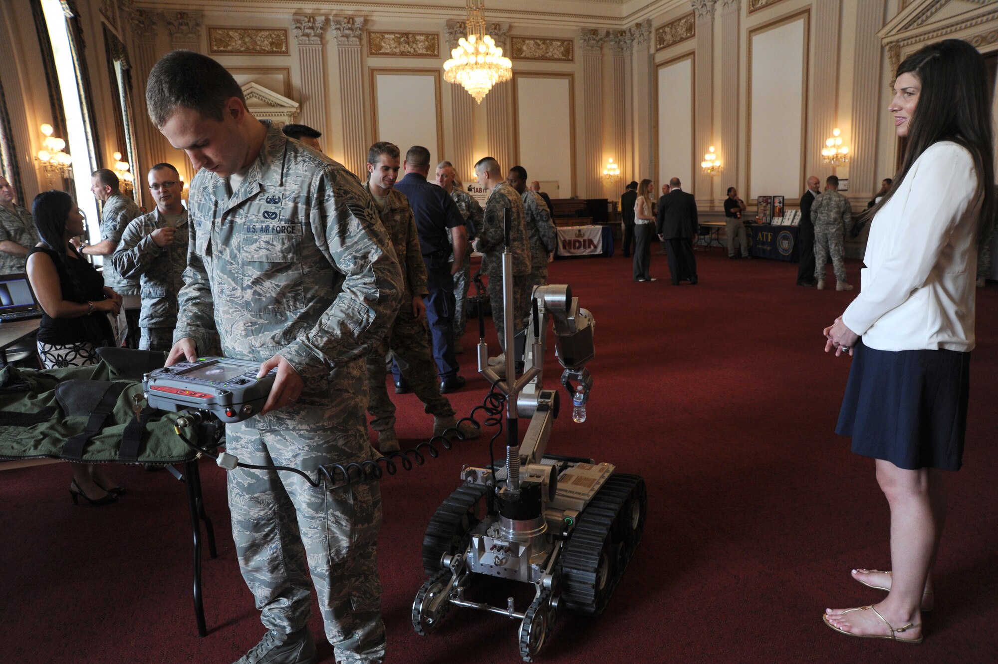 Senior Airman Brian Mink shows how he does not have to watch while using an explosive ordnance disposal Air Force Medium Size Robot to lift a bottle of water off the floor during EOD Day on the Hill in Washington June 12, 2014. EOD Day on the Hill is an annual event hosted by the Congressional EOD Caucus. The House EOD Caucus informs congressional members and staff about how EOD protects the nation’s interests and citizens at home and abroad. Mink is an 11th Civil Engineer Squadron EOD technician assigned to Joint Base Andrews, Maryland. (U.S. Air Force photo/Master Sgt. Tammie Moore)