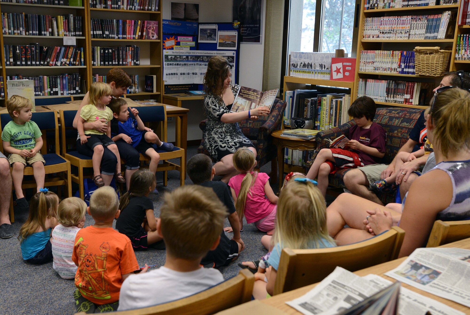 Gayla Campos, 31st Force Support Squadron library technician, reads to a group of children during “Story Time”, June, 17, 2014, at Aviano Air Base, Italy. Throughout the summer, the Aviano Base Library offers various events to Airmen and family members, to include Story Time and a military working dog demonstration in support of the “Paws to Read” summer reading program. (U.S. Air Force photo/Airman 1at Class Deana Heitzman)