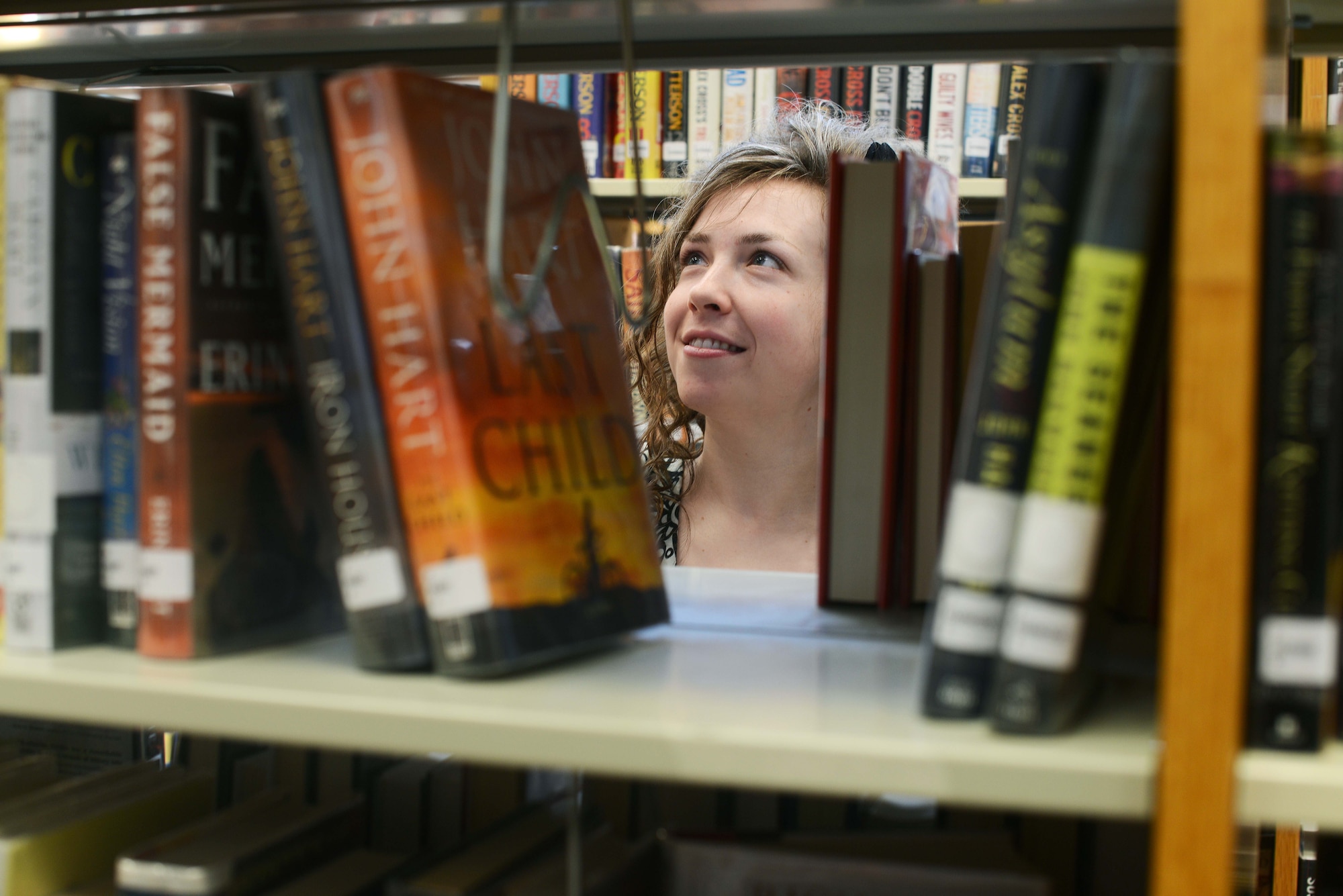 Gayla Campos, 31st Force Support Squadron library technician, searches for books before “Story Time,” June 17, 2014, at Aviano Air Base, Italy. Participants of the “Paws to Read” summer reading program can win prizes throughout the summer by reading personal books or books checked-out at the library. (U.S. Air Force photo/Airman 1st Class Deana Heitzman) 