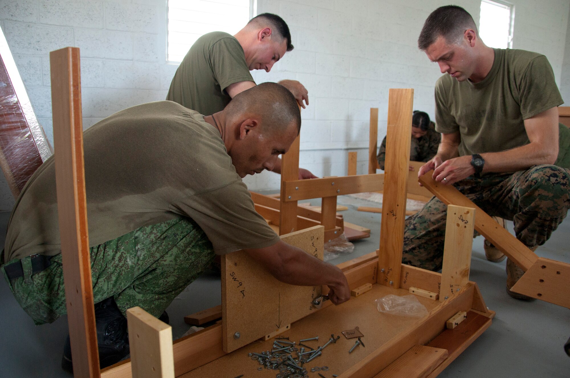 Belize Defence Force and U.S. military members assemble donated school desks at one of five New Horizons Belize 2014 construction sites June 3, 2014, at Edward P. Yorke school in Belize City, Belize. The civil affairs team worked with various non-government organizations, or NGOs, that donated school and medical supplies and furniture, and they also assisted during medical readiness training exercises in the northern Corozal District and southern Toledo District. (U.S. Air Force photo by Tech. Sgt. Kali L. Gradishar/Released)