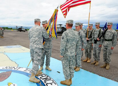 U. S. Army Lt. Col. Shane Mendenhall assumes command of the 1-228th Aviation Regiment at Soto Cano Air Base, Honduras by accepting the guidon from U. S. Army Col. Thomas Boccardi, the Joint Task Force-Bravo commander, June 16, 2014. Mendenhall assumed command from outgoing commander U. S. Army Lt. Col. E. J. Irvin, II. The 1-228th Aviation Regiment, under U. S. Army South, has directly supported the U. S. Southern Command's engagement and security cooperation strategy.  This one-of-a-kind battalion provides heavy lift, medical evacuation, general aviation and VIP support spanning the area of responsibility in support of Joint Task Force-Bravo.  The regiment has actively participated in counter narcotics missions and humanitarian assistance/disaster relief support throughout Central America.  (Photo by Martin Chahin)