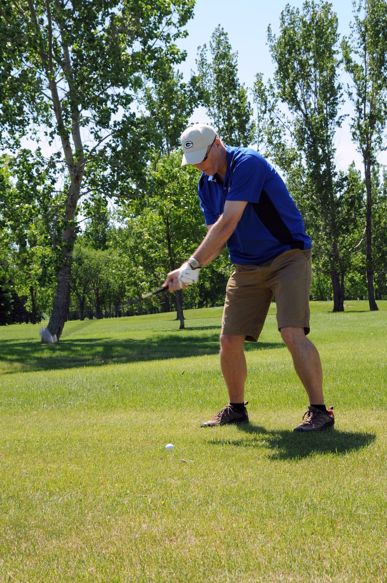 Col. Paul Bauman, 319th Air Base Wing commander, takes a swing during the first hole of the Military Affairs Committee golf tournament at Plainsview Golf Course on Grand Forks Air Force Base, N.D., June 17, 2014. The annual event teamed military and civilians as a way to build relations between the base and local community. (U.S. Air Force photo/Staff Sgt. David Dobrydney)