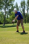 Col. Paul Bauman, 319th Air Base Wing commander, takes a swing during the first hole of the Military Affairs Committee golf tournament at Plainsview Golf Course on Grand Forks Air Force Base, N.D., June 17, 2014. The annual event teamed military and civilians as a way to build relations between the base and local community. (U.S. Air Force photo/Staff Sgt. David Dobrydney)
