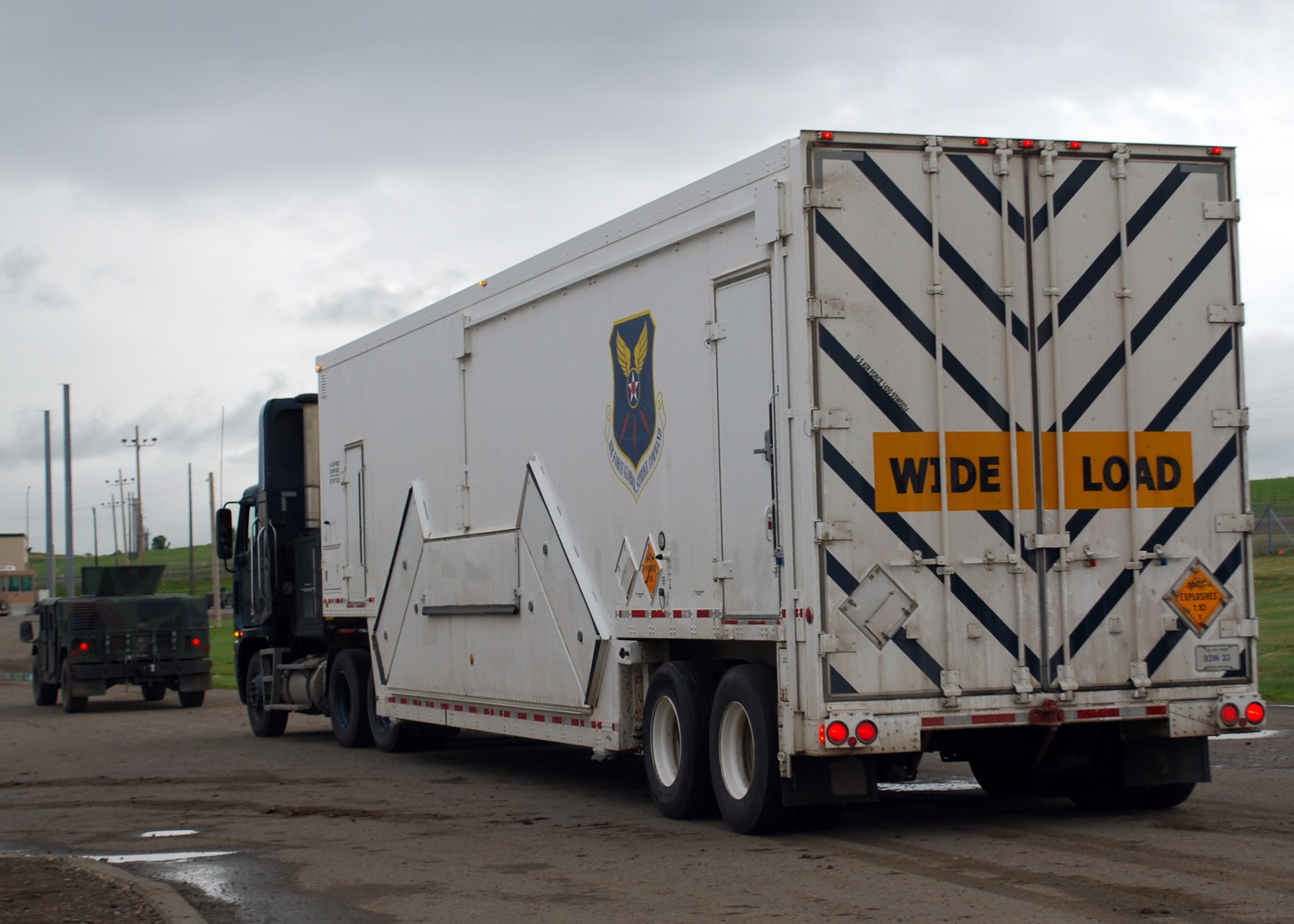 A convoy follows a payload transporter through the weapons storage area at Malmstrom Air Force Base, Montana, June 16. The PT returned after maintenance crews removed the last multiple independently targetable reentry vehicle in the Air Force intercontinental ballistic missile inventory from a Minuteman III, helping bring the Air Force towards compliance with the New Strategic Arms Reduction Treaty and comply with direction from the 2010 Nuclear Posture Review. (U.S. Air Force photo/Senior Airman Katrina Heikkinen)