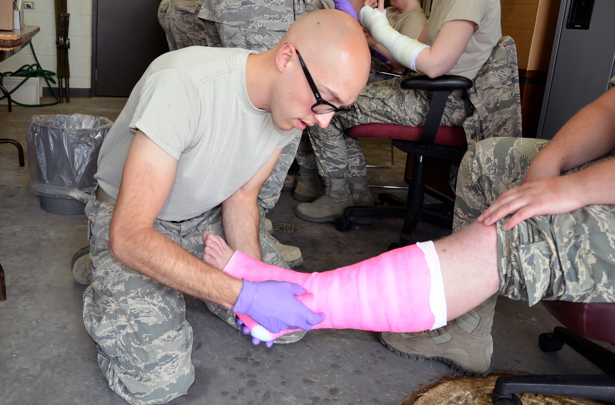 Senior Airman Devaroux Stanga, 114th Medical Group medic, applies a cast to the leg of Senior Airman Austin Meyers, also a medic, during annual training at Joe Foss Field, S.D. June 17, 2014.  Members of the 114th Fighter Wing are spending annual training at home station this year as part of the unit's Unit Effectiveness Inspection.  Medics with the unit will practice skills such as casting and suturing during their week of hands on training. (National Guard photo by Senior Master Sgt. Nancy Ausland/Released)