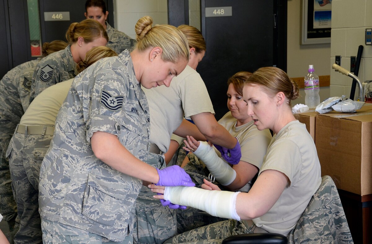 Tech. Sgt. Danielle Rivera, 114th Medical Group medic, applies a cast to the arm of 1st Lt. Gwen Smith, 114th Medical Group Physician Assistant, during annual training at Joe Foss Field, S.D. June 17, 2014.  Members of the 114th Fighter Wing are spending annual training at home station this year as part of the unit's Unit Effectiveness Inspection.  Medics with the unit will practice skills such as casting and suturing during their week of hands on training. (National Guard photo by Senior Master Sgt. Nancy Ausland/Released)