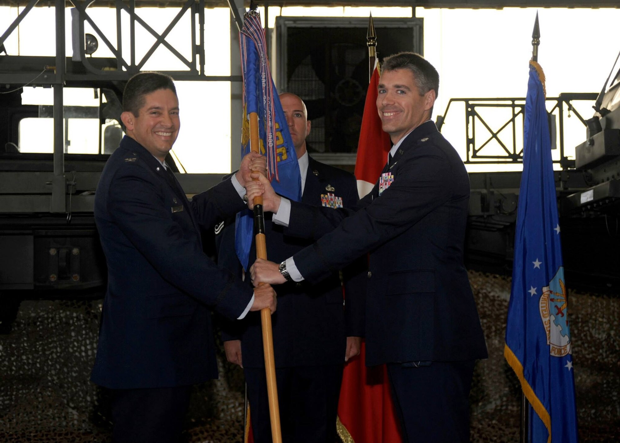 Col. Carlos Ortiz, 521st Air Mobility Operations Group commander, passes the quideon to Lt. Col. George Buch, 728th Air Mobility Squadron commander, during a change of command ceremony June 16, 2014, Incirlik Air Base, Turkey. The ceremony signified the transition of command from Lt. Col. Henry Triplett to Buch. (U.S. Air Force photo by Staff Sgt. Veronica Pierce/Released)