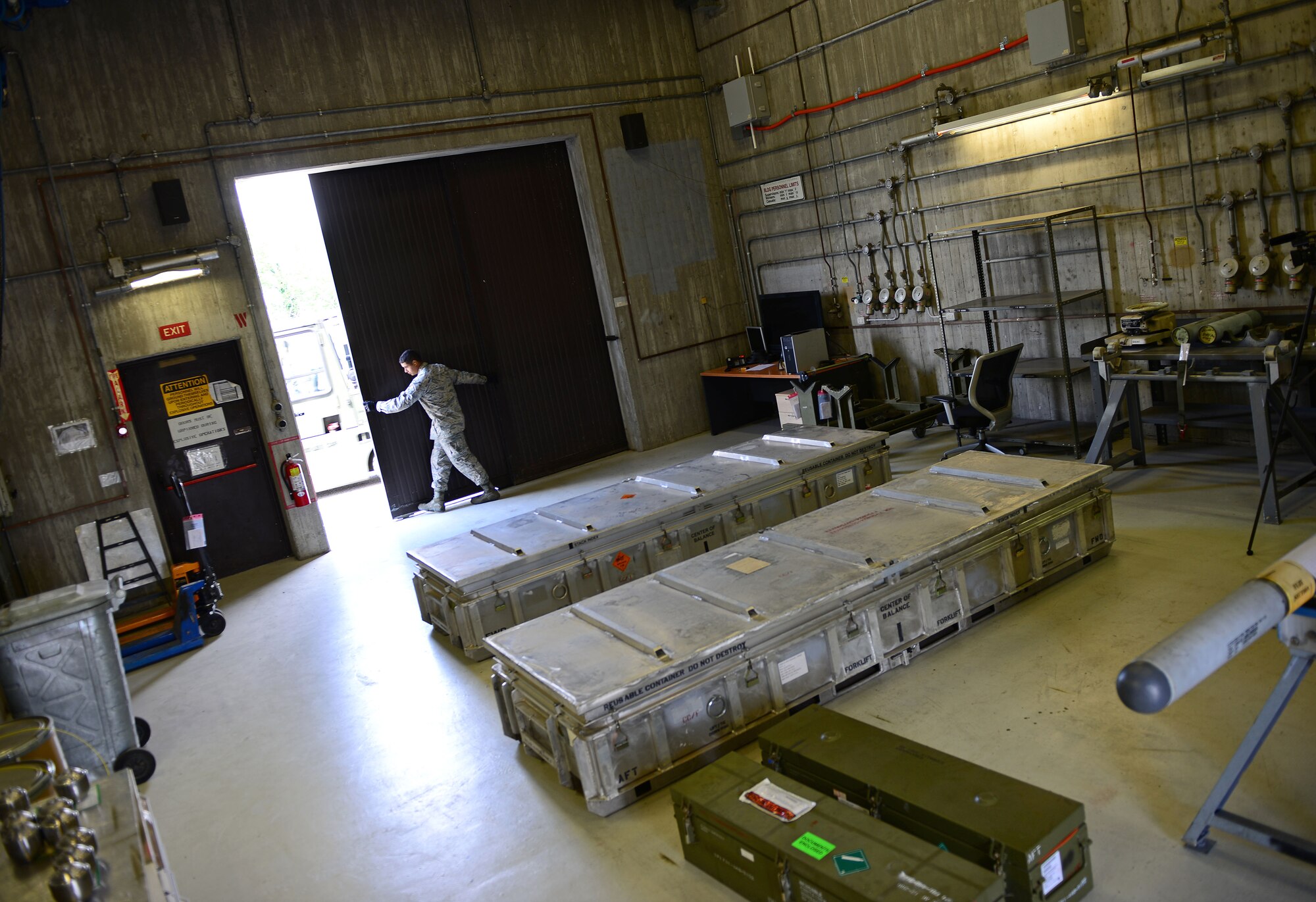 Airman 1st Class Joseph Girone Jr., 31st Munitions Squadron storage crew member, closes a munitions storage facility shop door, June 16, 2014, at Aviano Air Base, Italy. Within the 31st MUNS, six separate flights work together to provide support to include armament, production, materiel, weapons, systems and programs. (U.S. Air Force photo/Senior Airman Matthew Lotz)