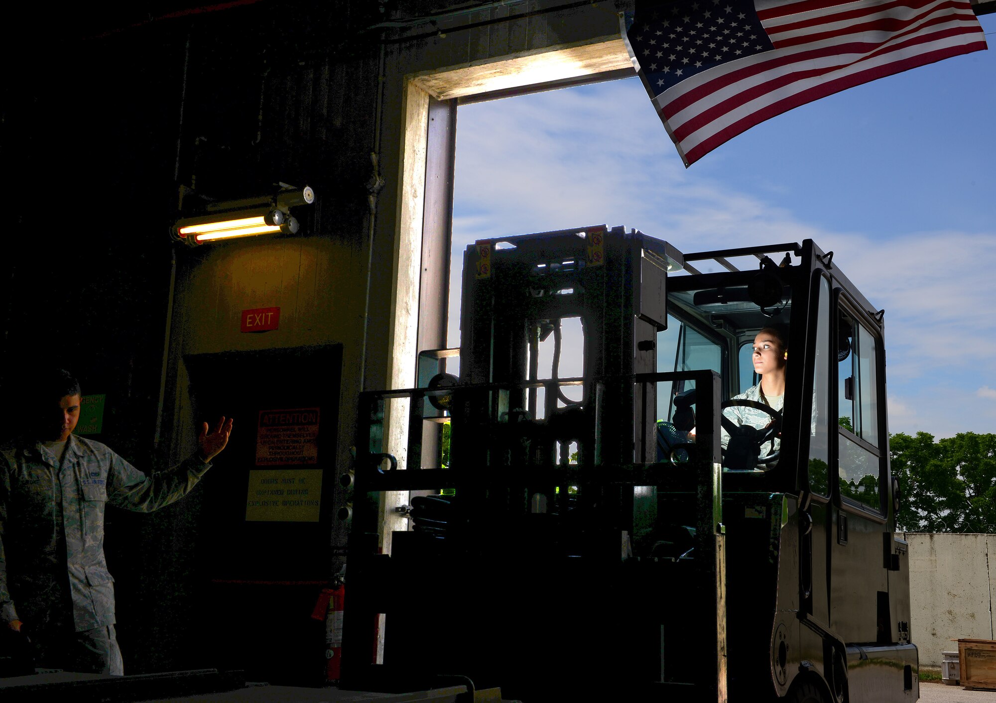 Airman 1st Class Joseph Girone Jr. guides Airman 1st Class Shayla Hasbrouck, 31st Munitions Squadron storage crew members, into a munitions shop, June 16, 2014, at Aviano Air Base, Italy. When munitions are transported between geographically-separated bases, it is the storage section’s responsibility to carefully unload and transport the assets to the storage facilities. (U.S. Air Force photo/Senior Airman Matthew Lotz)