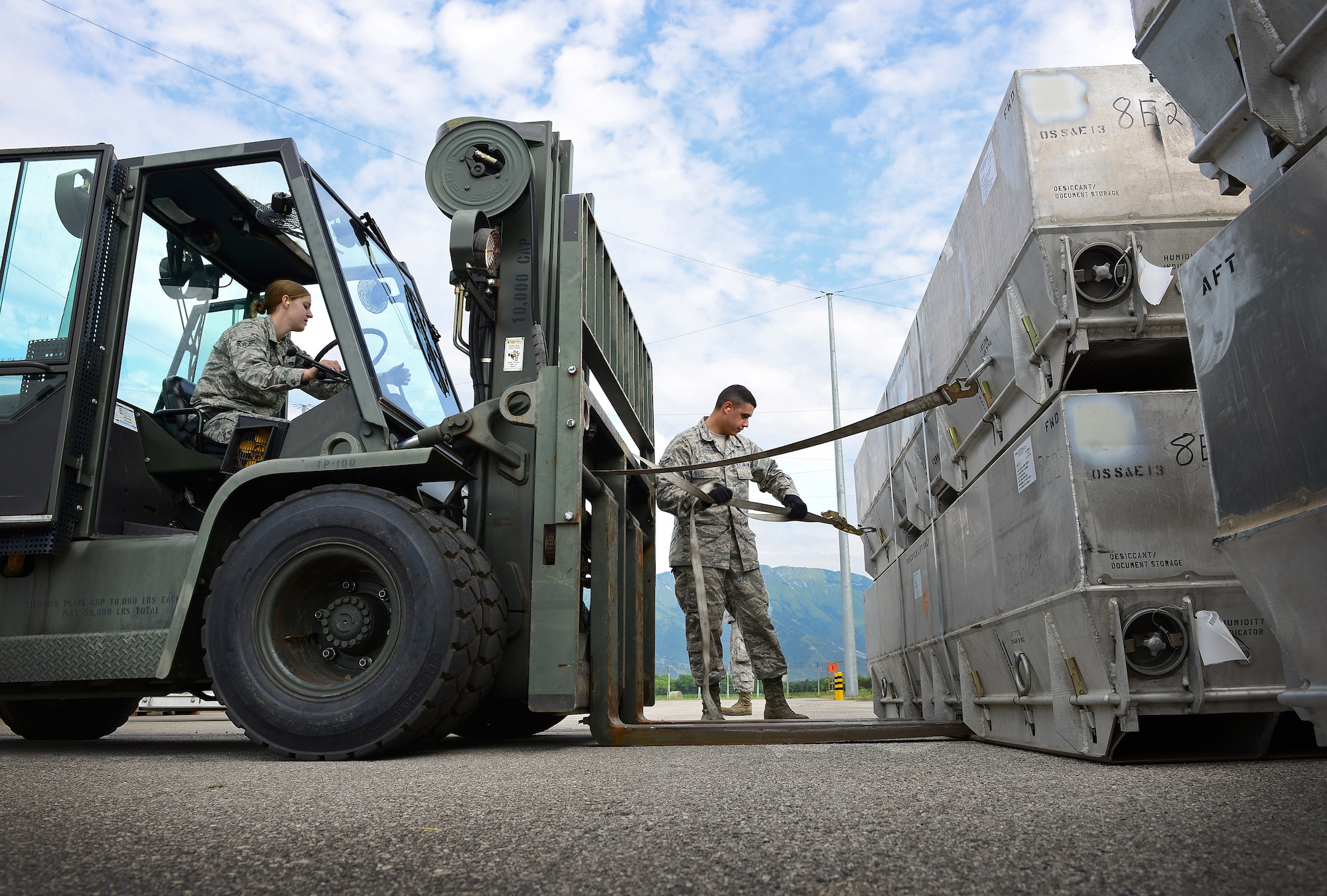 Airman 1st Class Rebecca Dalton operates a forklift as Airman 1st Class Joseph Girone Jr. secures a strap to a munitions box, June 12, 2014, at Aviano Air Base, Italy. When munitions are transported between geographically-separated bases, it is the storage section’s responsibility to carefully unload and transport the assets to the storage facilities. Dalton and Girone are 31st Munitions Squadron storage crew members. (U.S. Air Force photo/Senior Airman Matthew Lotz)