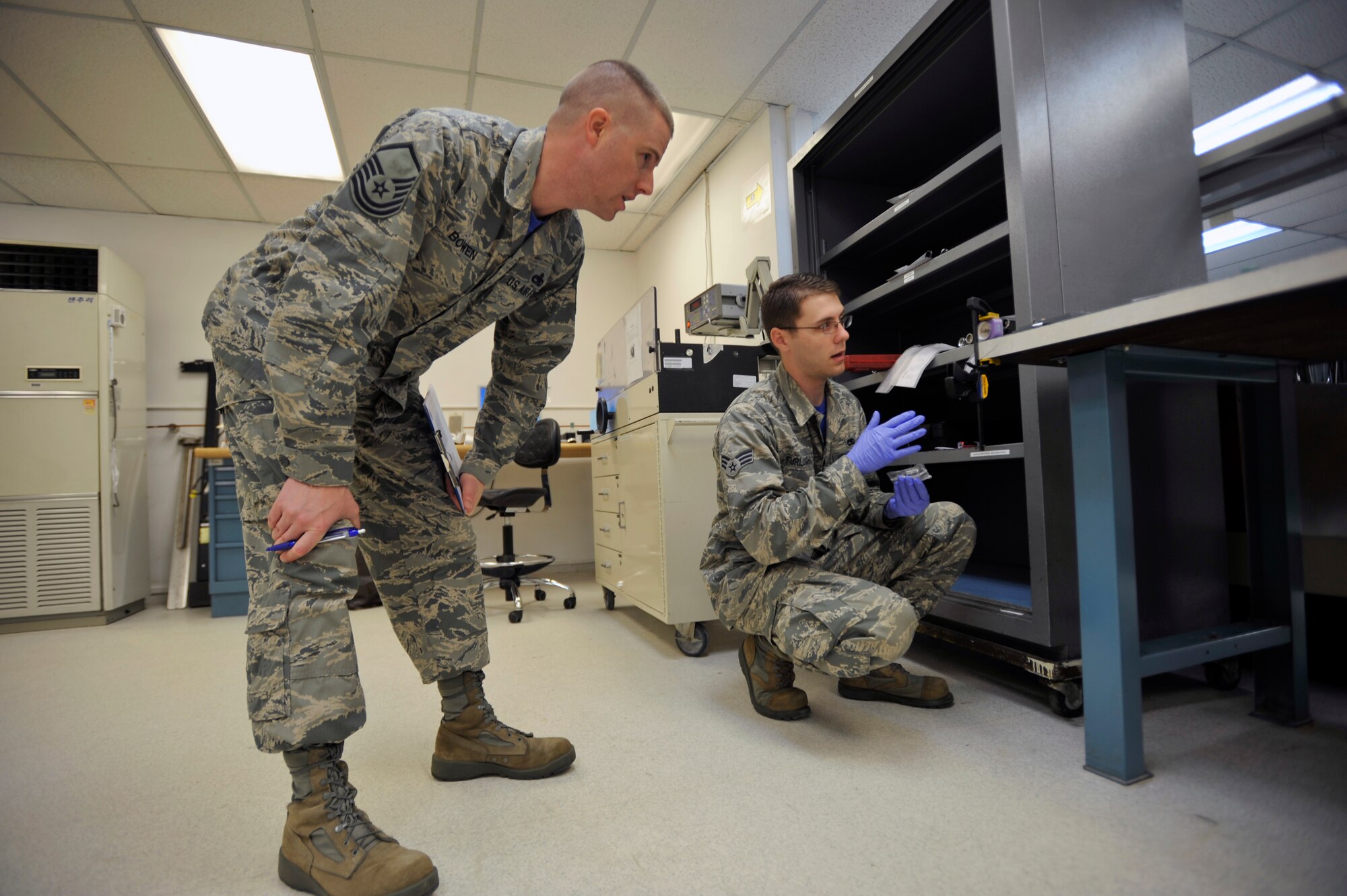 Master Sgt. Thomas Bowen, 51st Maintenance Squadron flight test, measurement and diagnostic equipment chief and quality manager, oversees Senior Airman Matthew Furlough, 51st MXS physical dimensional precision measurement equipment laboratory technician, during a priority calibration process review of an F-16 force applicator Osan Air Base, Republic of Korea, June 13, 2014. Bowen verified Furlough correctly performed the job during the quality assurance inspection. (U.S. Air Force photo/Senior Airman David Owsianka)