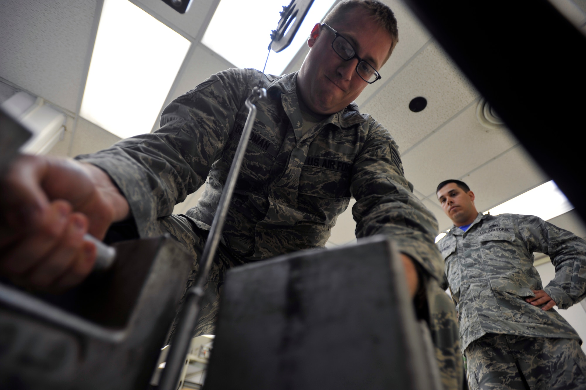 Tech. Sgt. Josh Hulbert, 51st Maintenance Squadron precision measurement equipment laboratory section supervisor, right, conducts a process review as Staff Sgt. Arien Goldman, 51st Maintenance Squadron physical dimensional PMEL technician, calibrates a torque transducer on Osan Air Base, Republic of Korea, June 6, 2014. A torque transducer measures and records the torque on a rotating system. (U.S. Air Force photo/Senior Airman David Owsianka)