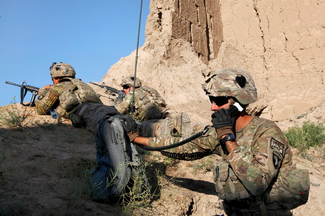 U.S. Army Spc. Tyler Buchanan, foreground, conducts a radio check inside an abandoned fortress in Petawa village in Afghanistan's Parwan province, June 13, 2014. Buchanan is assigned to the 101st Airborne Division's Company A, 1st Battalion, 2nd Brigade Combat Team, Task Force Strike.