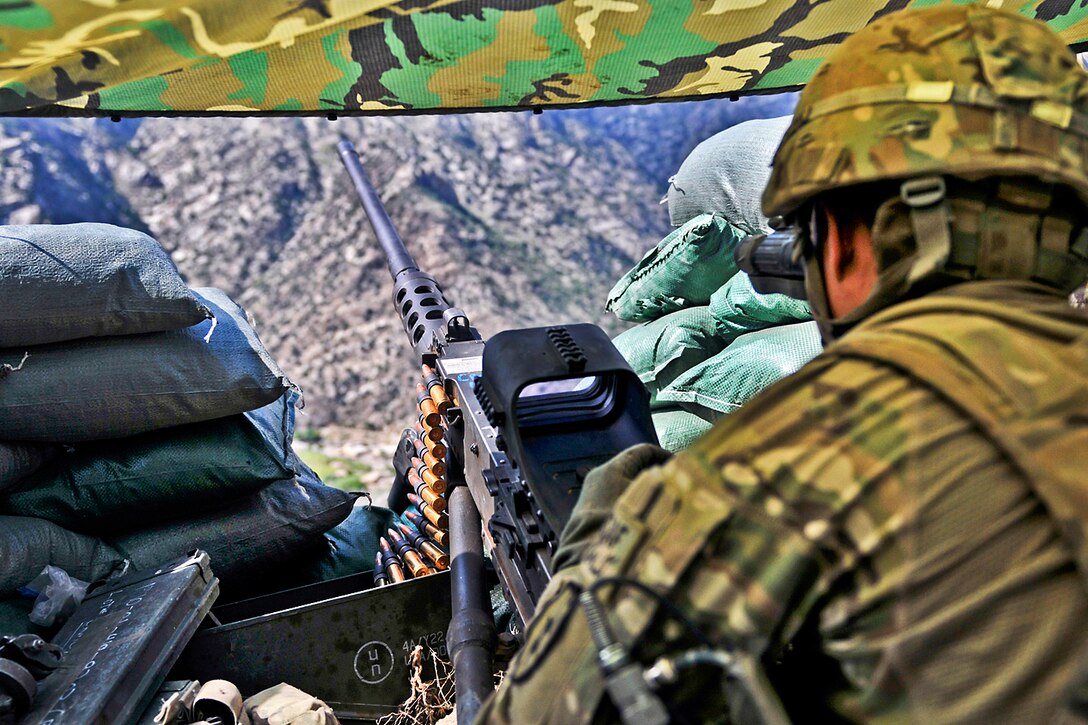 A U.S. soldier looks out into the Waygul Valley from his fighting position while manning a .50-caliber machine gun in Wanat Village, Afghanistan, Sept. 22, 2011. The soldier is assigned to the 25th Infantry Division's 3rd Brigade.  
