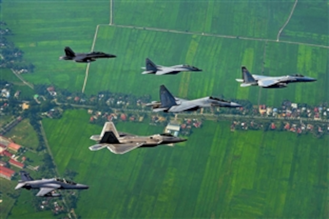 A formation of U.S. and Malaysian aircraft fly in formation during Cope Taufan, a biennial military exercise, over Penang, Malaysia, June 18, 2014. The exercise is designed to improve readiness and cooperation between the U.S. and Malaysia, and includes numerous air operations.