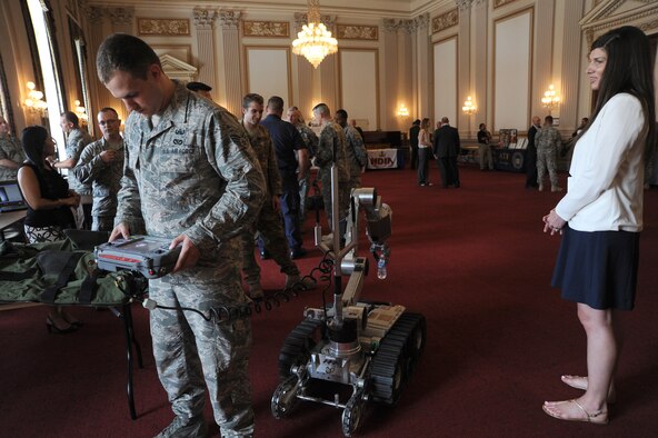Senior Airman Brian Mink shows how he does not have to watch while using an explosive ordnance disposal Air Force Medium Size Robot to lift a bottle of water off the floor during EOD Day on the Hill June 11, 2014, in Washington, D.C. EOD Day on the Hill is an annual event hosted by the Congressional EOD Caucus. The House EOD Caucus informs congressional members and staff about how EOD protects the nation’s interests and citizens at home and abroad. Mink is an 11th Civil Engineer Squadron EOD technician assigned to Joint Base Andrews, Md. (U.S. Air Force photo/Master Sgt. Tammie Moore)