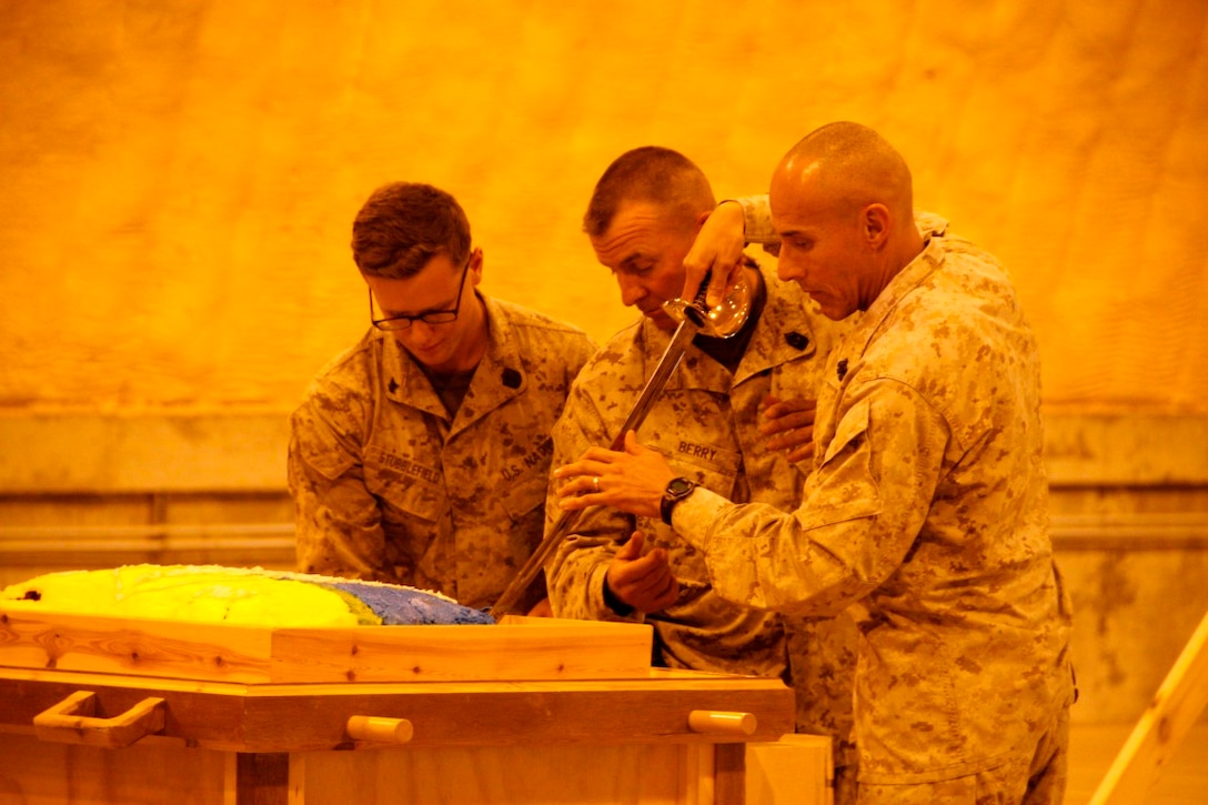 United States Navy Master Chief Frank Dominguez, right, command master chief, Regional Command (Southwest), cuts the corpsman birthday cake with Sgt. Maj. Douglas E. Berry, Jr., center, sergeant major, RC(SW), during a ceremony for the 116th birthday of the United States Navy's Hospital Corps held aboard Camp Leatherneck, Afghanistan, June 17, 2014. The cake cutting was with the youngest and oldest corpsmen on Camps Bastion and Leatherneck. At the conclusion of the ceremony, the corpsmen recited their Hospital Corpsman's Pledge.