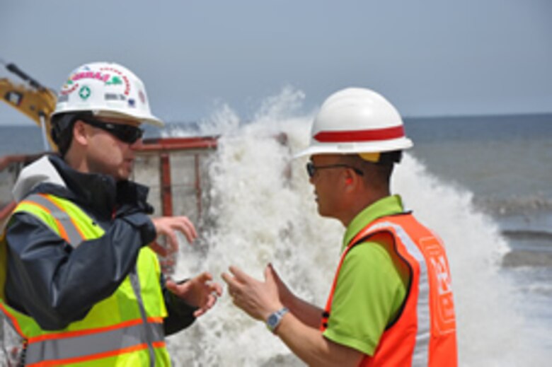 Project Engineer Young Kim (right) discusses an item with a contractor May 7, 2014 during sand placement in Keansburg, New Jersey, an area severely eroded by Hurricane Sandy. The initiative is part of a larger effort by the New York District placing nearly one million cubic yards of sand onto three miles of shoreline along Raritan Bay to repair and restore the previously-engineered beach and dune there impacted by Hurricane Sandy. 