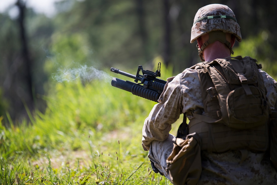 Cpl. Eli Goff, Company B ceremonial marcher at Marine Barracks Washington, D.C., reloads an M203 grenade launcher at the range for grenade launchers and M240 B machine guns in Quantico, Va., June 18, 2014. The Marines regularly train for combat situations as well as their ceremonial duties. (Official Marine Corps photo by Cpl. Dan Hosack/Released)