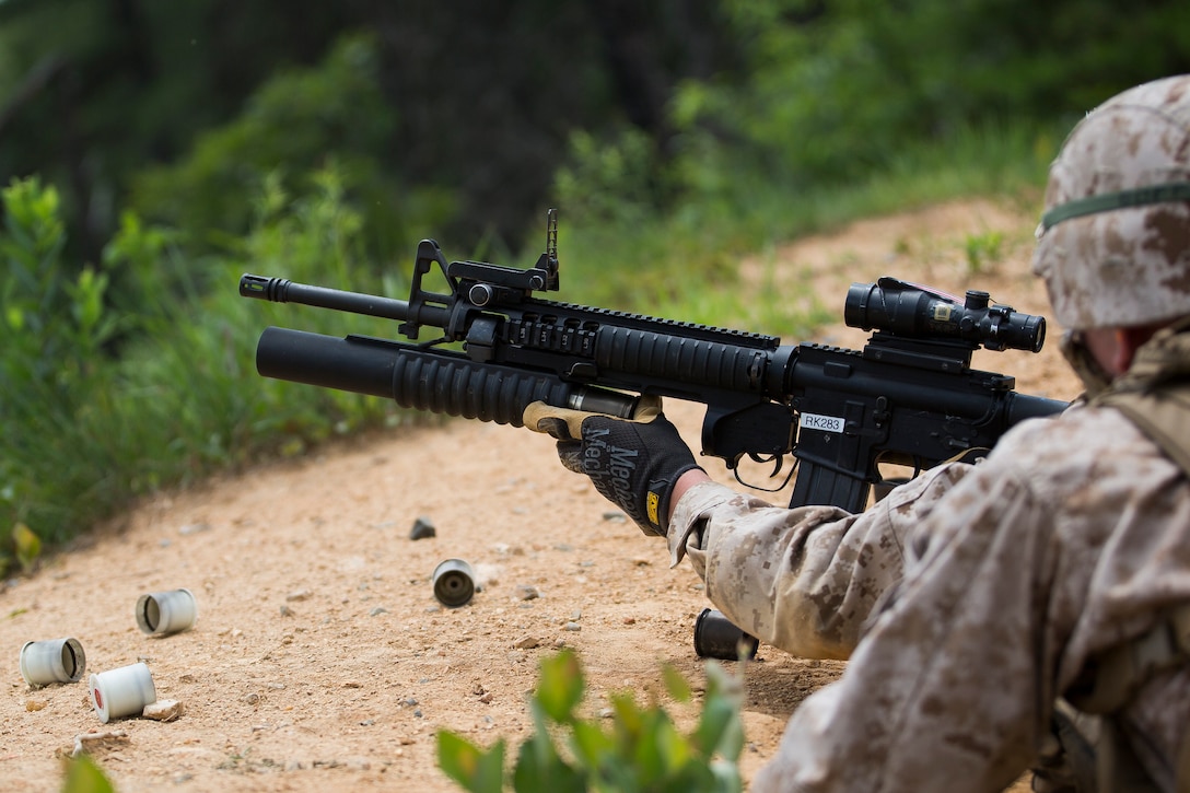 A Company B ceremonial marcher at Marine Barracks Washington, D.C., reloads an M203 grenade launcher at the range for grenade launchers and M240 B machine guns in Quantico, Va., June 18, 2014. The Marines regularly train for combat situations as well as their ceremonial duties. (Official Marine Corps photo by Cpl. Dan Hosack/Released)