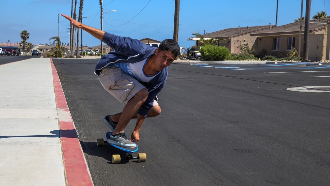 Sergeant Richard Hernandez, cyber network technician, 15th Marine Expeditionary Unit, rides his longboard aboard Camp Pendleton, Calif., June 13, 2014. Hernandez, 22, is from Temecula, Calif. (U.S. Marine Corps photo by Lance Cpl. Anna Albrecht/Released)