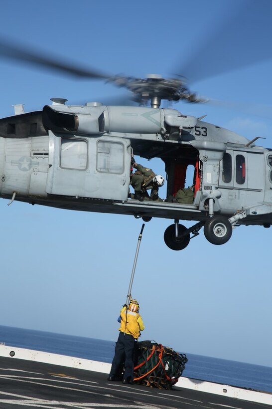 Sailors with the USS San Diego air department hook a cargo pallet on an MH-60S Sea Hawk with Helicopter Sea Combat Squadron 23 (HSC-23) as part of a vertical replenishment exercise from the flight deck during Certification Exercise (CERTEX) off the coast of Southern California, June 18, 2014. CERTEX is comprised of a specific series of missions intended to evaluate and certify the 11th Marine Expeditionary Unit for their upcoming deployment with the Makin Island Amphibious Ready Group scheduled for later this summer. (U.S. Marine Corps photo by Cpl. Jonathan R. Waldman/RELEASED)