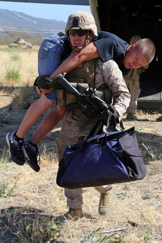 A Marine the 11th Marine Expeditionary Unit  fireman carries a role player acting as an injured patient as part of a mass casualty training exercise during Certification Exercise (CERTEX) at Camp Pendleton, California, June 15, 2014.  The 11th MEU and Amphibious Squadron 5 team conduct CERTEX to hone mission-essential tasks, execute specified MEU and Amphibious Ready Group operations, and certify the foundation of a cohesive warfighting team for exercises and operations they may encounter in their upcoming deployment. (U.S. Marine Corps photo by Lance Cpl. Laura Y Raga/Released)